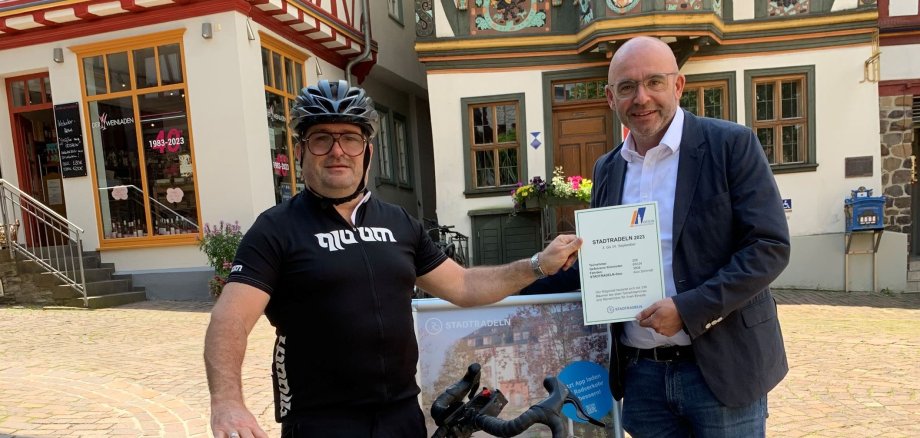 Stadtradel-Star Alex Schmidt und Bürgermeister Christian Herfurth mit einem Fahrrad vor dem Killingerhaus