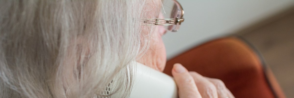 Ältere Frau mit Telefonhörer in der Hand