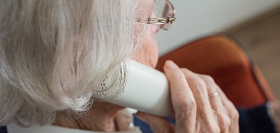 Ältere Frau mit Telefonhörer in der Hand